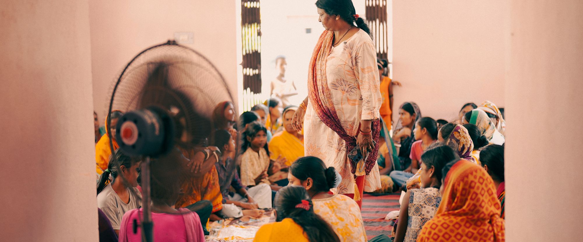 Women and children seated together during a community education session in India