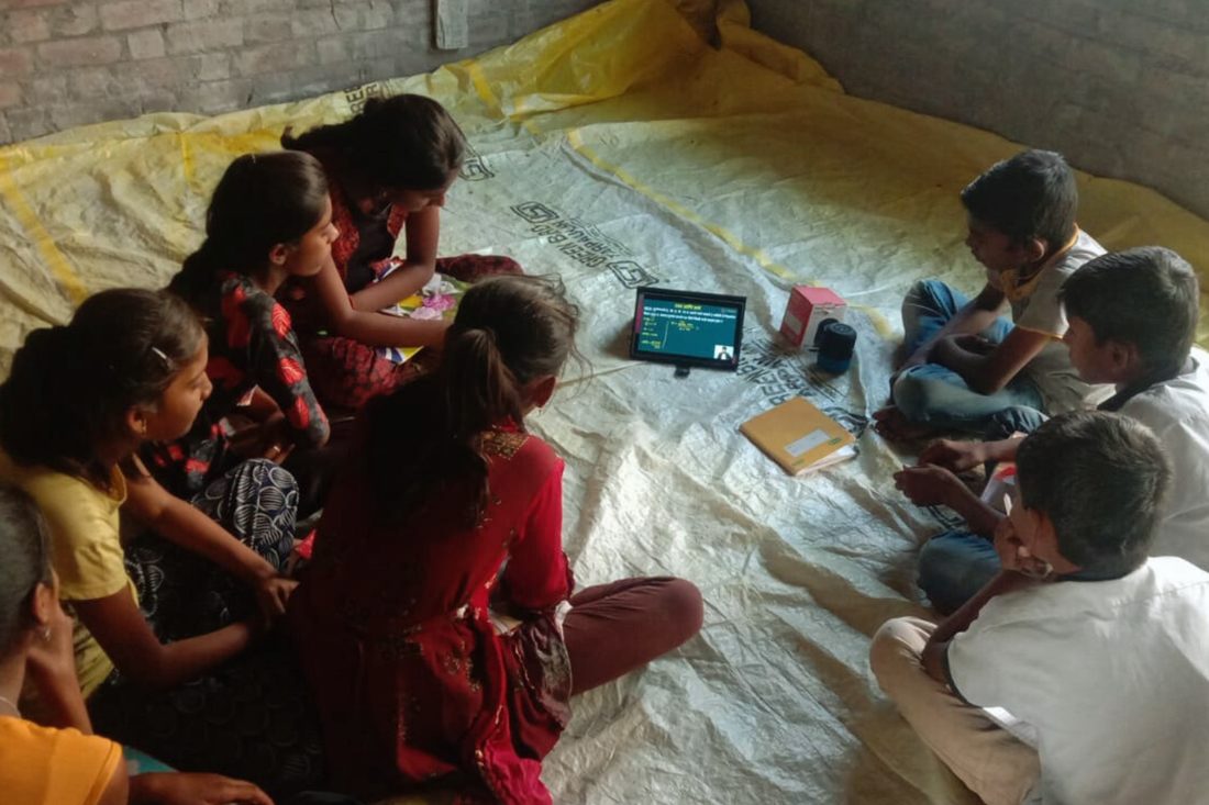 Children gathered around a tablet for a learning session at home